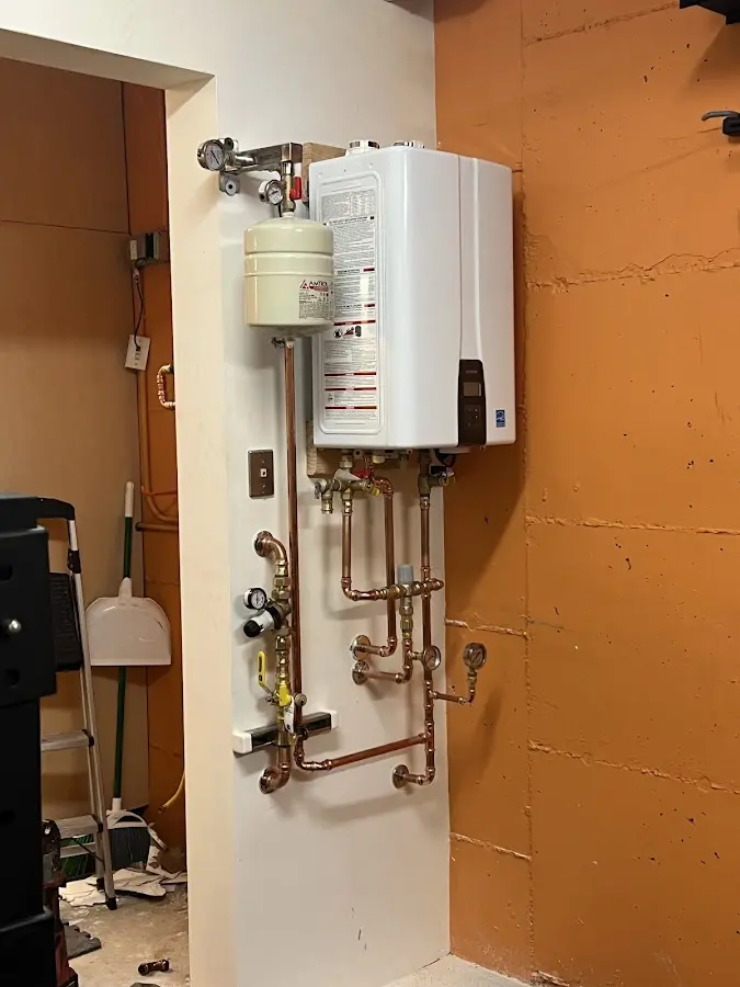 Plumbing technician inspecting water heater connections in Cassville